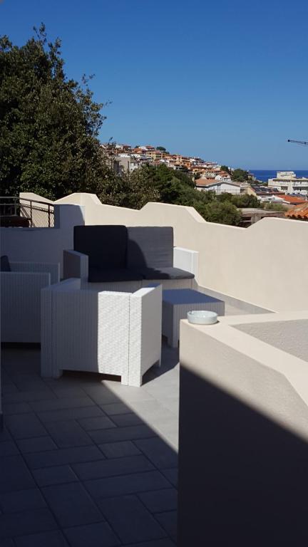 a balcony with white furniture and a view of the city at Seliche in Cala Gonone