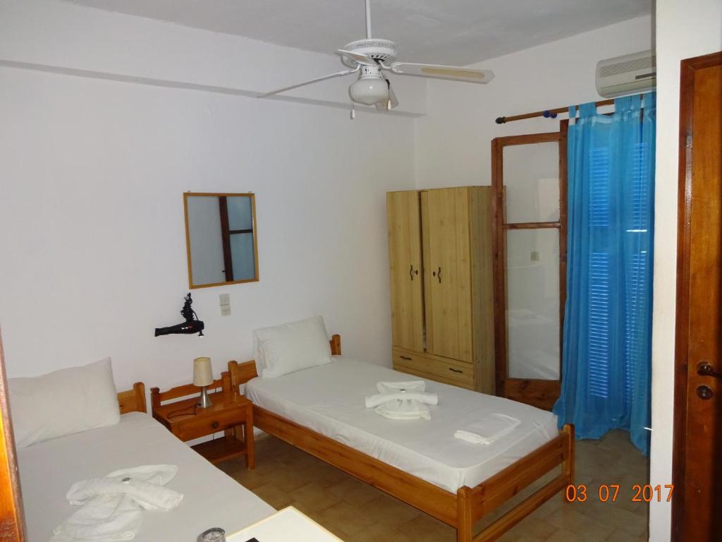 Habitación pequeña con 2 camas y ventana en Scirocco Rooms en Loutro