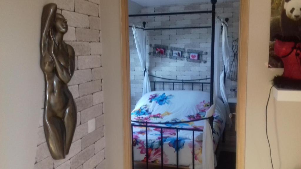 een slaapkamer met een bed en een bakstenen muur bij pastelle in Contres