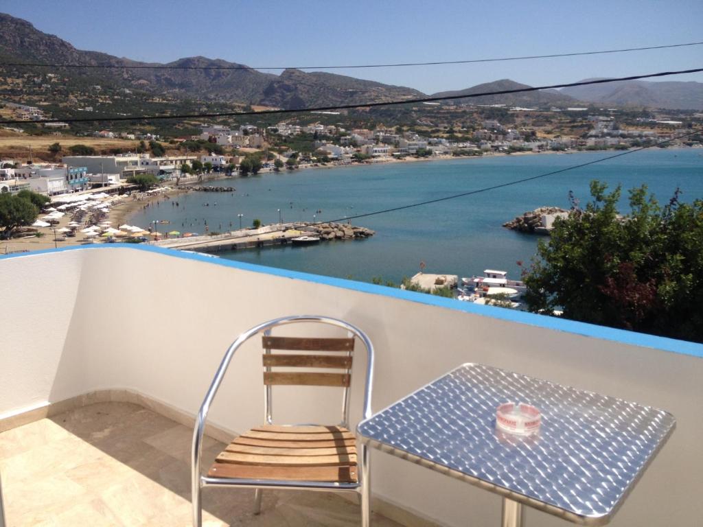 a chair on a balcony with a view of the water at Creta Sun Apartments in Makrigialos Sea-view in Makry Gialos