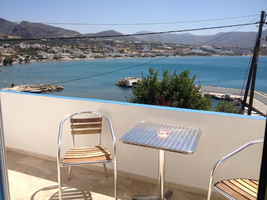 a table and chairs on a balcony with a view of the water at Creta Sun Apartments in Makry Gialos