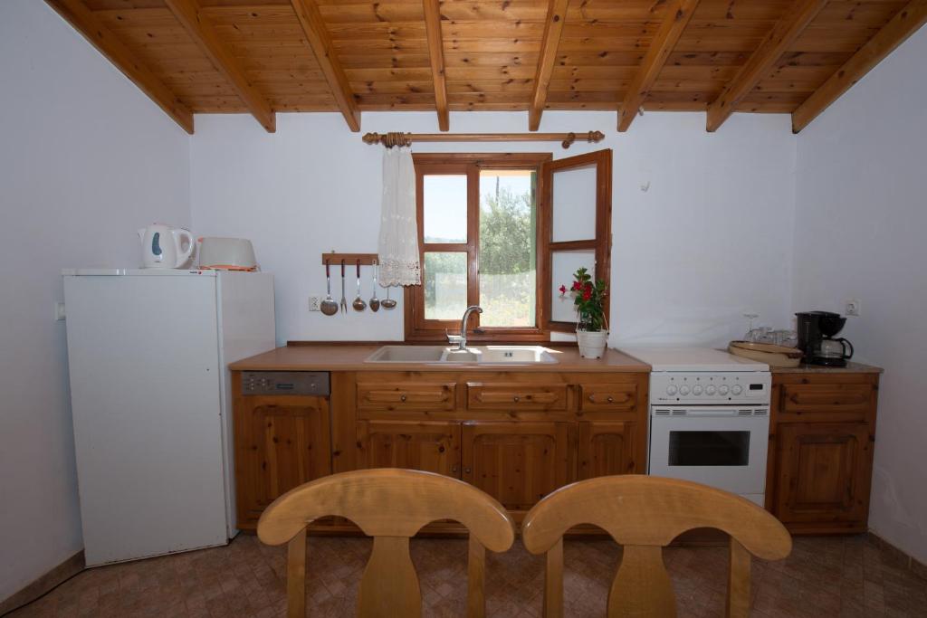 kuchnia ze zlewem i 2 krzesłami w obiekcie Villa Hera w mieście Simi