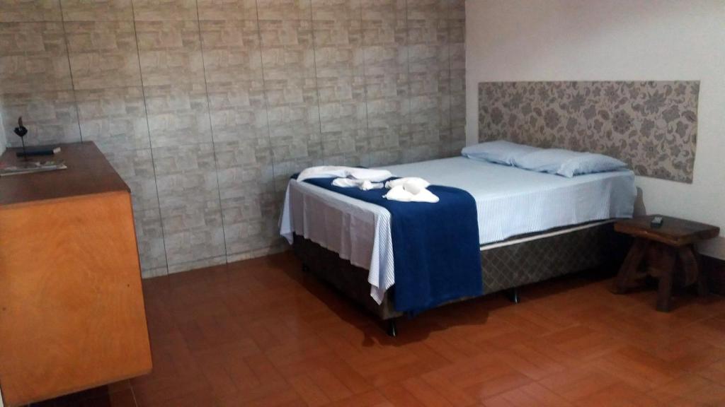 1 dormitorio con 1 cama y toallas en una mesa en Pousada Portal, en Chapada dos Guimarães