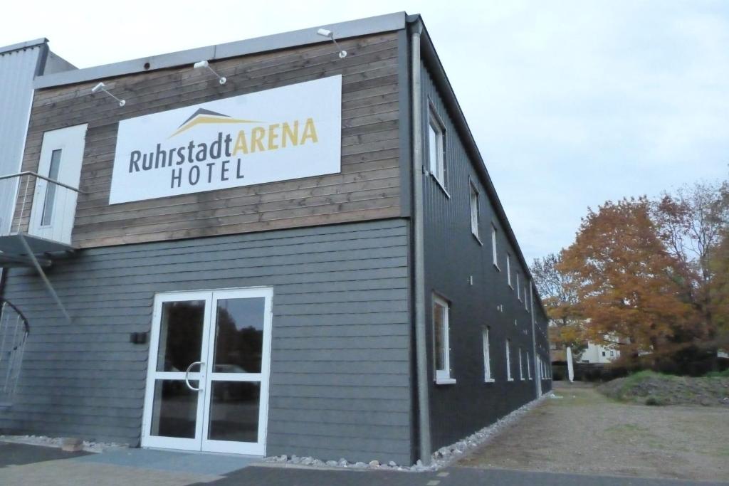 a building with a sign on the side of it at Ruhrstadtarena Hotel in Herne