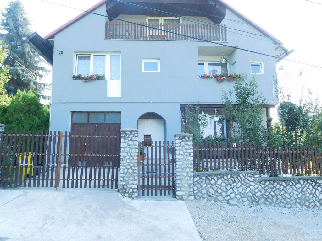 uma casa azul com um portão e uma cerca em Napfény Vendégház em Miskolctapolca