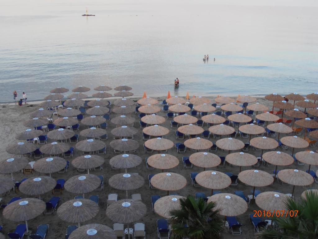 un grupo de sombrillas y sillas en una playa en Oscar en Paralia Katerinis