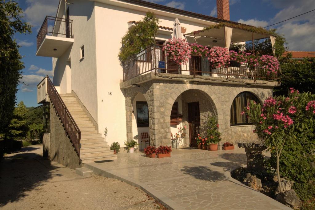 a house with flowers on the side of it at Apartments Cvelic Milovcic in Malinska