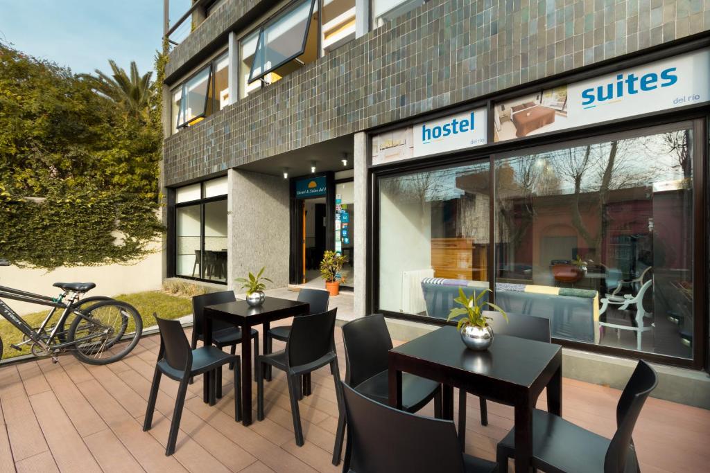 a patio with tables and chairs in front of a building at Hostel & Suites del Rio in Colonia del Sacramento