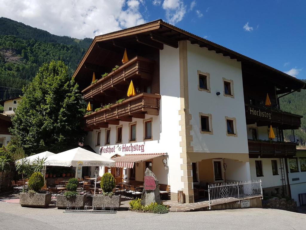 a large building with a restaurant in front of it at Gasthof Hochsteg in Finkenberg
