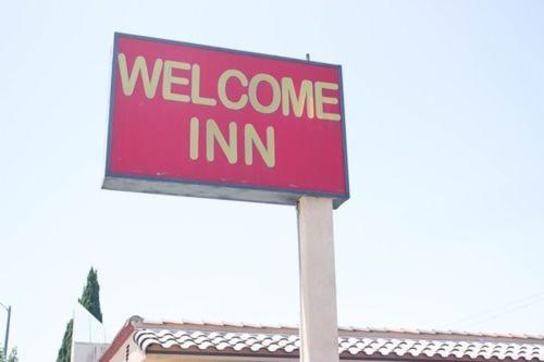 a red welcome inn sign in front of a building at Welcome Inn in Inglewood