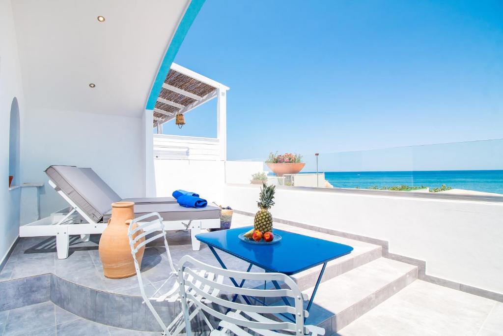 a patio with a table and chairs and the ocean at Dimitra Boutique Rooms in Faliraki
