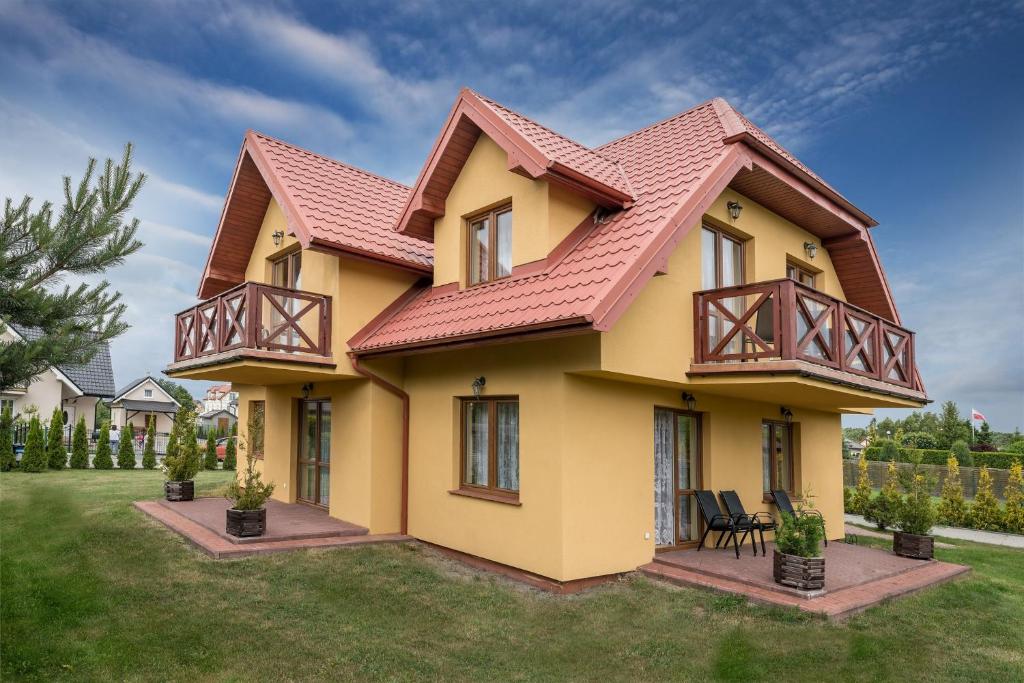 a yellow house with a red roof at Villa Klaudia in Dębki