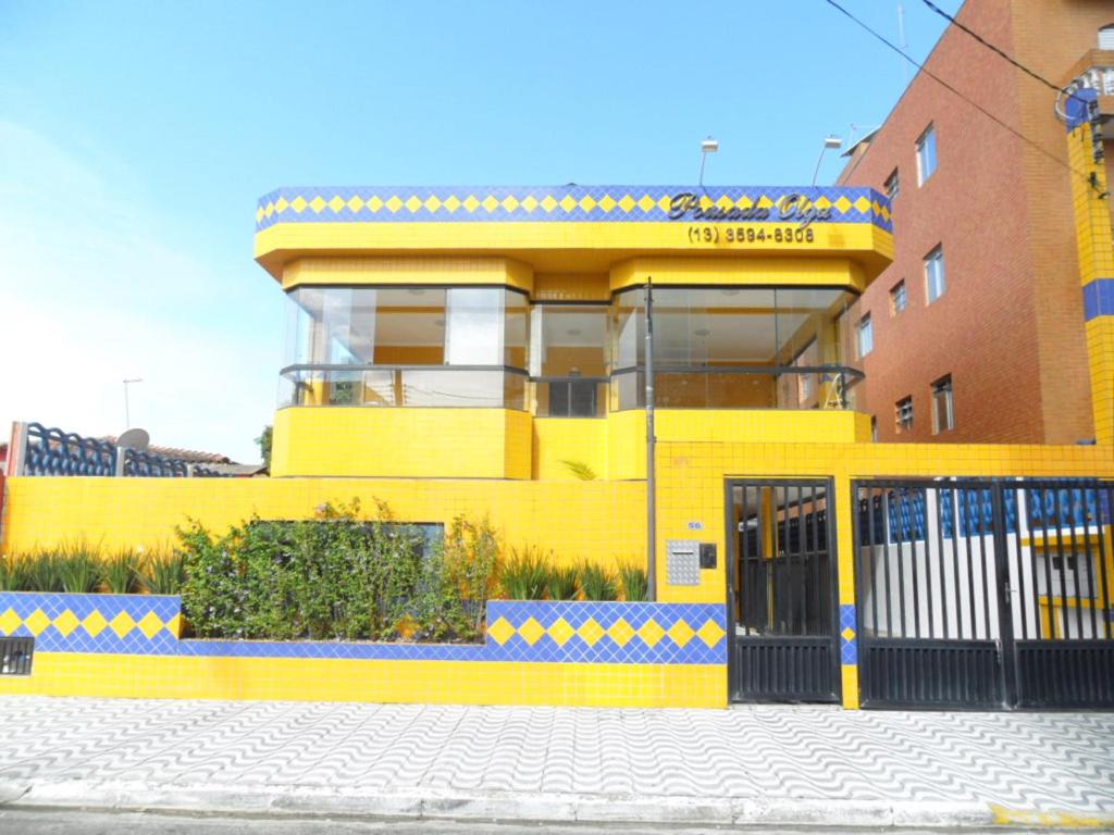 un edificio amarillo con una puerta delante en Pousada Olga en Solemar