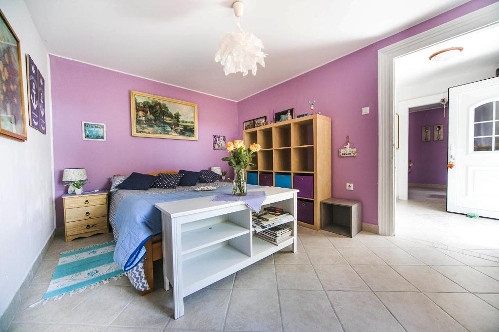 ein lila Schlafzimmer mit einem Bett und einem Schreibtisch in der Unterkunft Cozy Istrian House in Izola