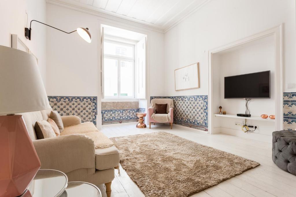 een witte woonkamer met een bank en een tv bij Baixa Tile Blue Two-Bedroom Apartment - by LU Holidays in Lissabon