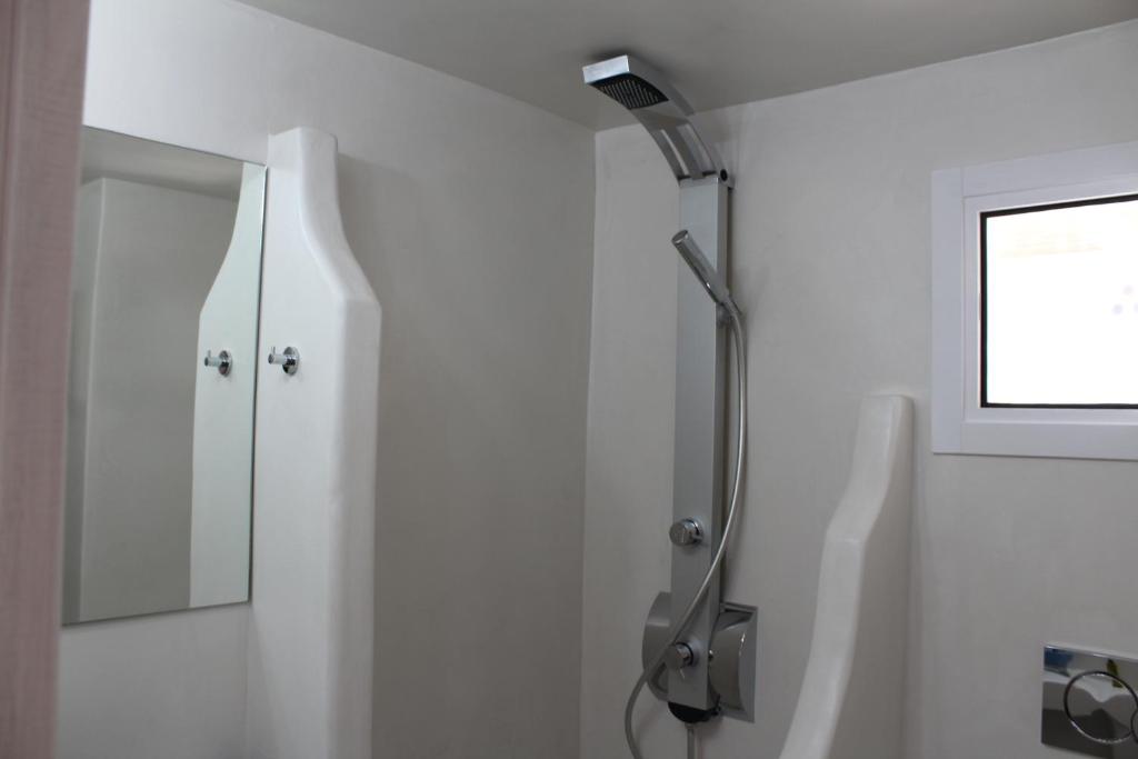 a shower in a white bathroom with a window at Studios Betty in Plaka Milou