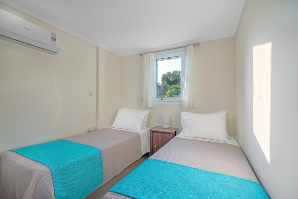 Łóżko lub łóżka w pokoju w obiekcie Thea Villas Aegina