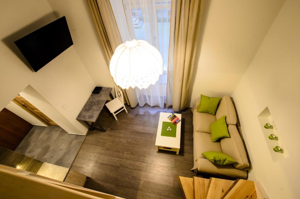 a living room with a couch and a chandelier at Apartamenty Winnicy Kresy II in Krakow