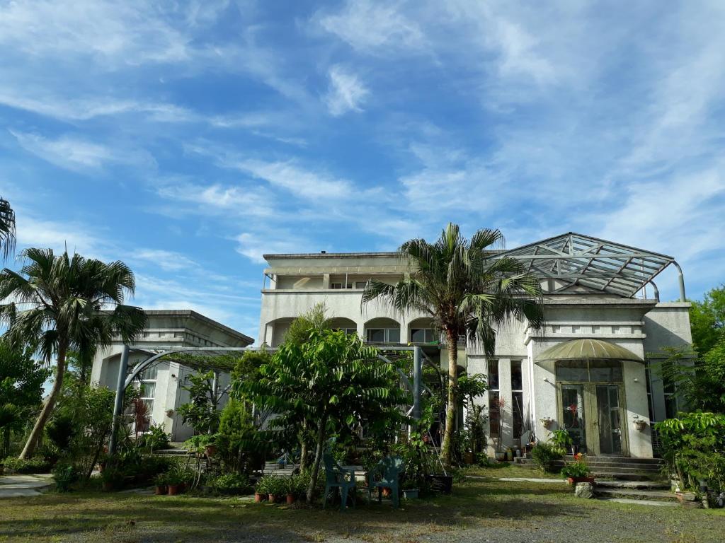 a house with palm trees in front of it at Light and Shadow B&B in Yuanshan