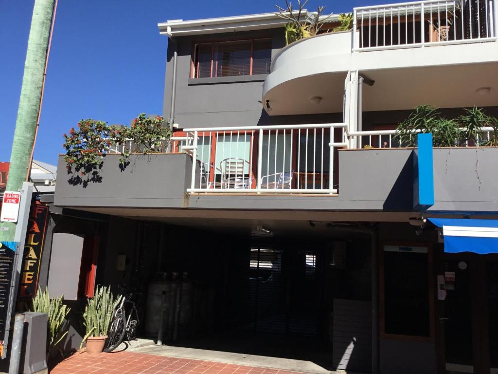 an apartment building with a balcony and a patio at Byron Beach House in Byron Bay