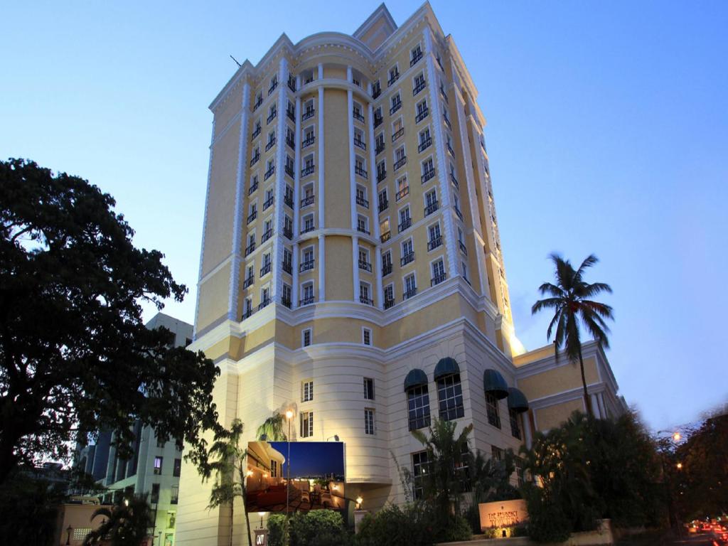 a large white building with a palm tree in front of it at The Residency Towers in Chennai