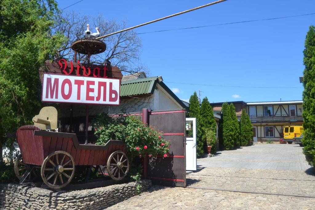 a sign for a motel with a wagon outside at Hotel Vivat in Velikodolinskoye