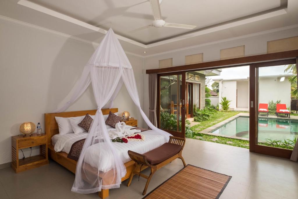 a bedroom with a bed with a mosquito net at Laba Ubud Villa in Ubud