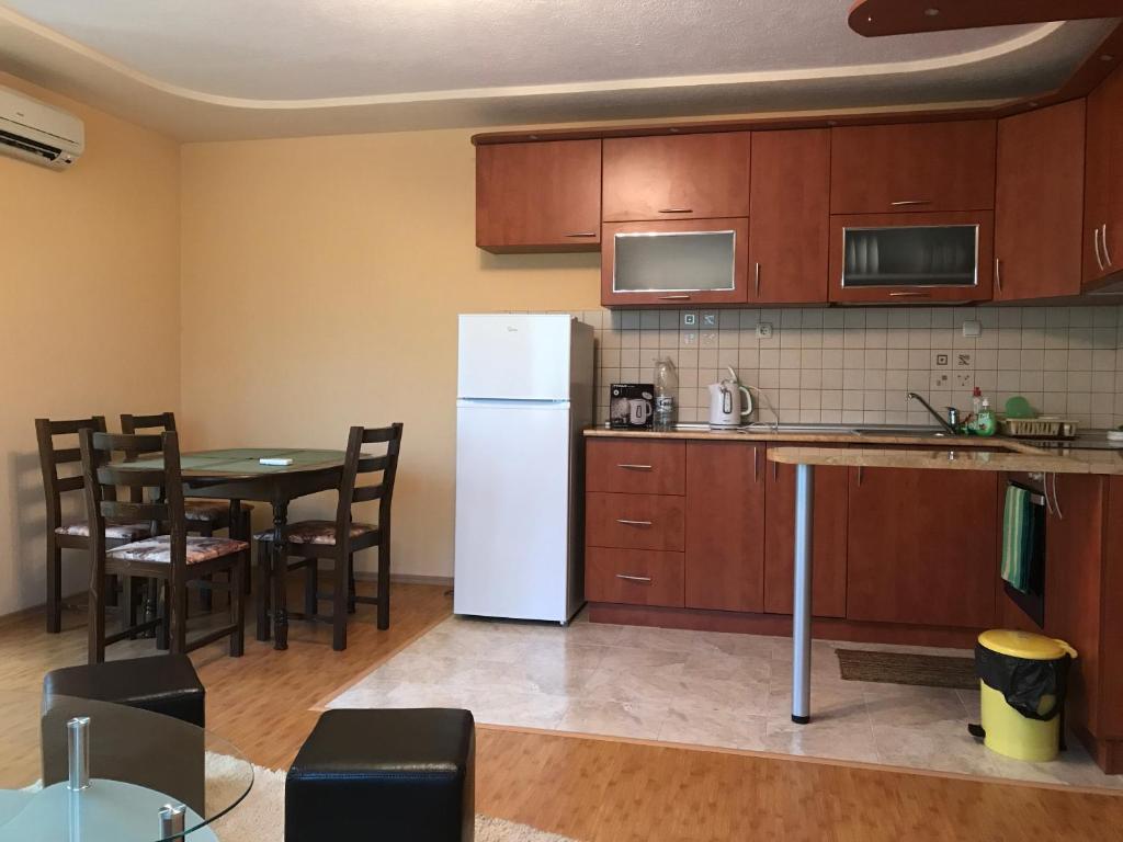a kitchen with a table and a white refrigerator at Apartment Elena in Sandanski
