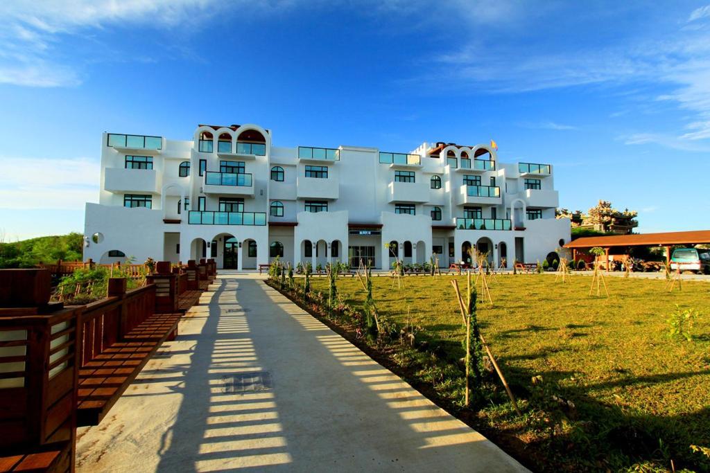 a large white building with a field in front of it at Long Xing B&B in Huxi