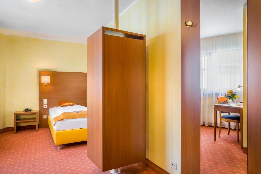 a room with a bedroom with a bed and a door at Hotel Rega Stuttgart in Stuttgart