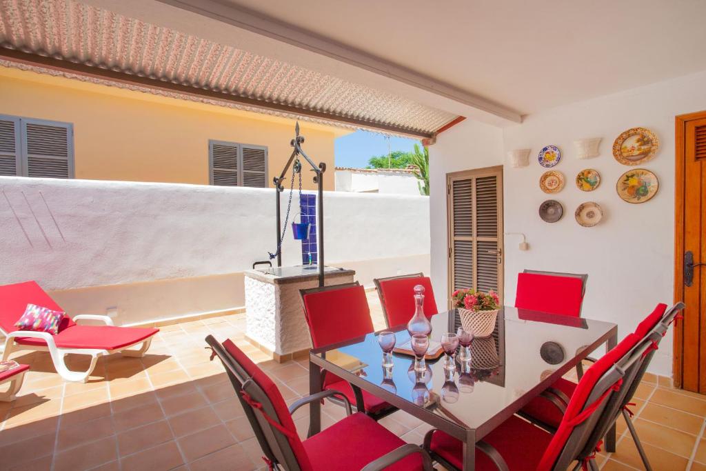 a dining room with a table and red chairs at Villa Xavier in Can Picafort