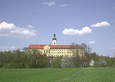 duży budynek z wieżą na szczycie pola w obiekcie Gasthof Hotel Rückerl w mieście Walderbach