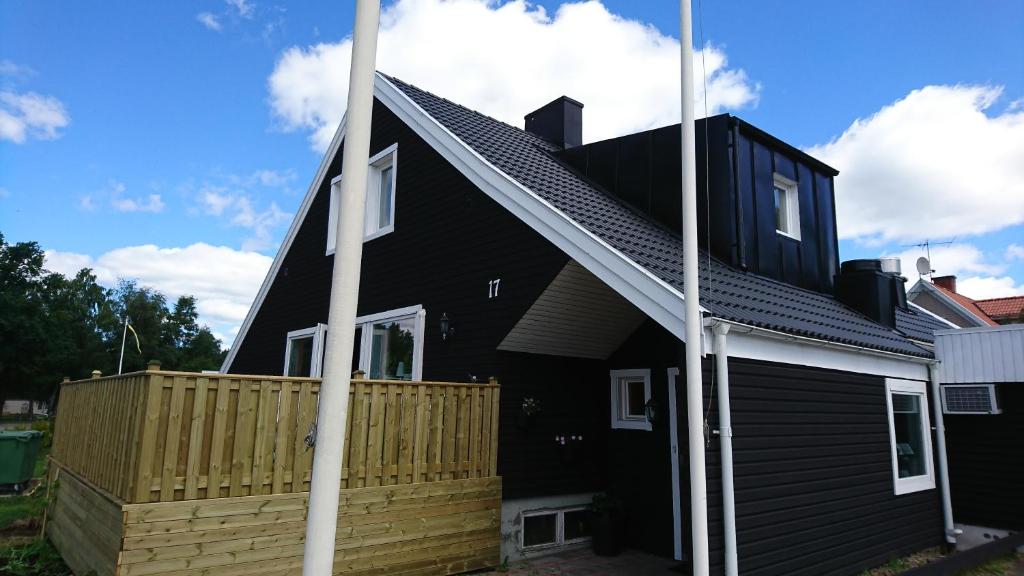 a black house with a wooden fence in front of it at Guest House Tidaholm in Tidaholm