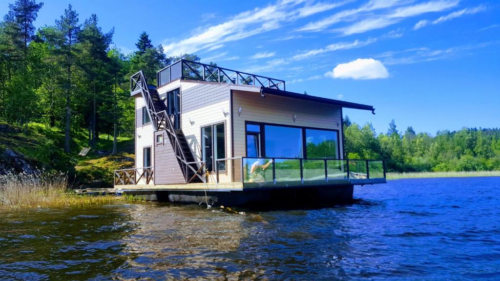 een huis op een dok op een waterlichaam bij HouseBoat Kovcheg in Lachdenpochja