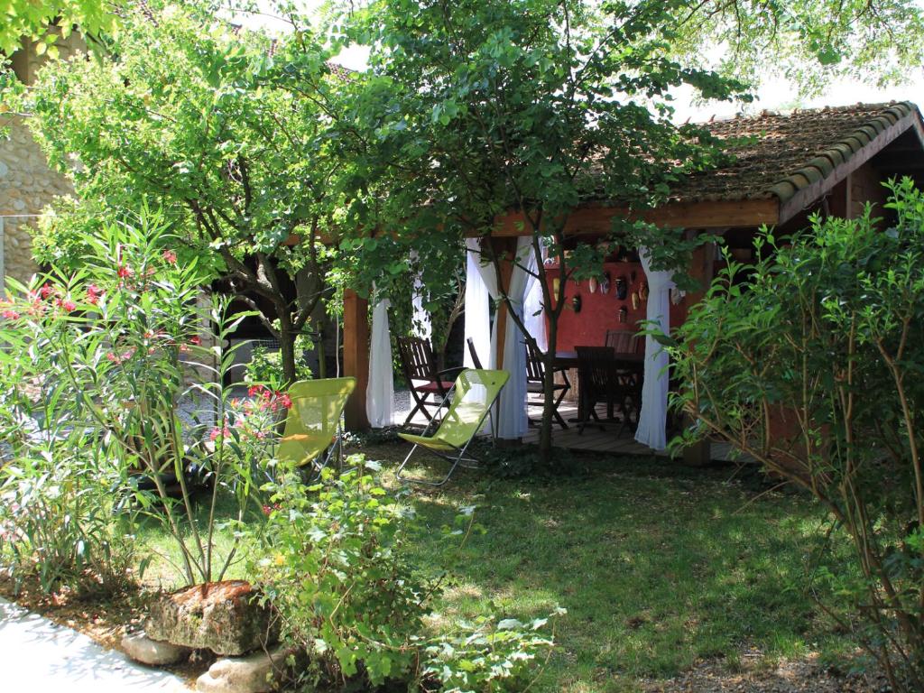 een huis met een tafel en stoelen in een tuin bij Les Pascals in Saint-Paul-lès-Romans