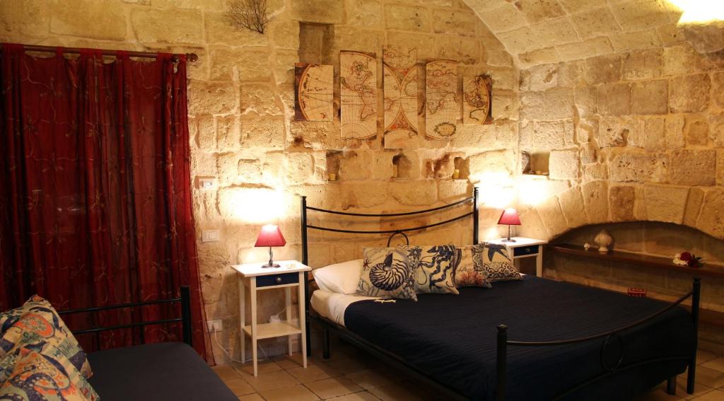 een slaapkamer met een bed in een stenen muur bij Locazione breve Nautilus - Antica dimora indipendente con patio in Monopoli