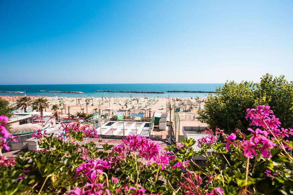 vista su una spiaggia con fiori rosa di Hotel Gaia a Rimini