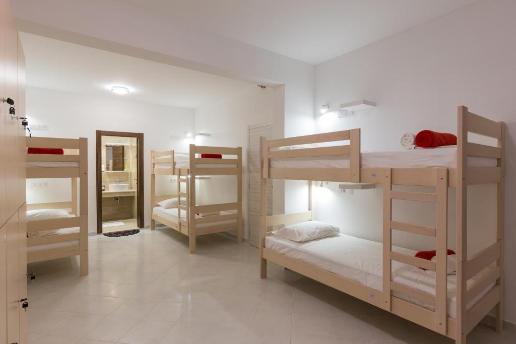 a room with four bunk beds in a room with a mirror at Hostel Free Bird in Dubrovnik