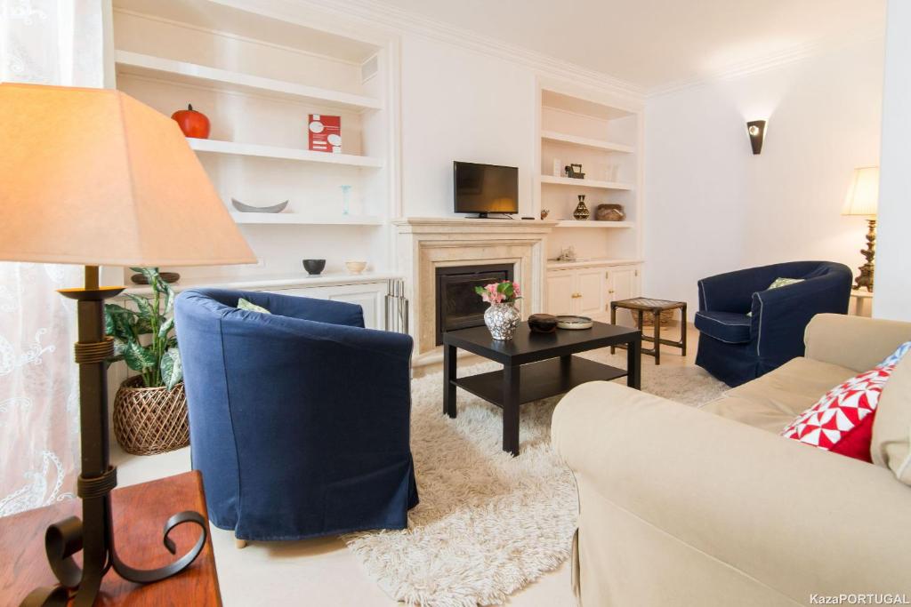 a living room with blue chairs and a fireplace at Gomes Freire Terrace in Cascais