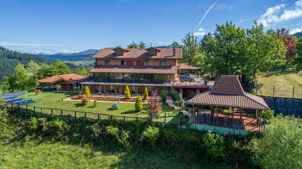 - une vue aérienne sur une grande maison sur une colline dans l'établissement Hotel & Spa Etxegana, à Zeanuri
