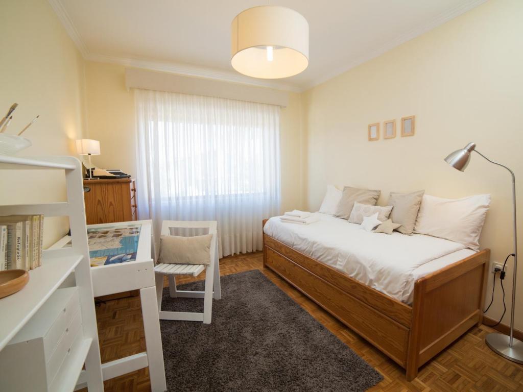 um pequeno quarto com uma cama e uma secretária em OPORTO GUEST Vila do Conde River & Sea em Vila do Conde