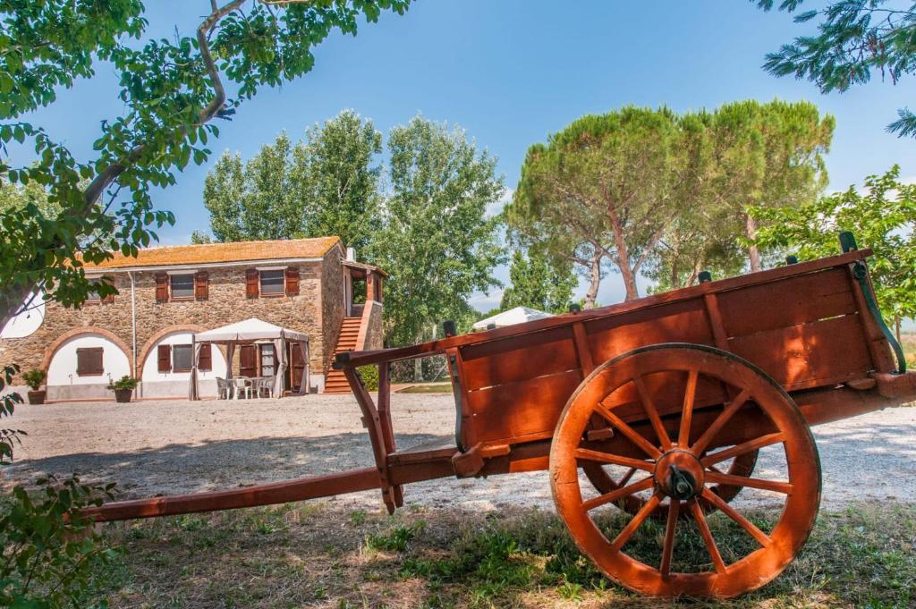 un carro de madera expuesto frente a un edificio en Podere i Giganti, en Scarlino