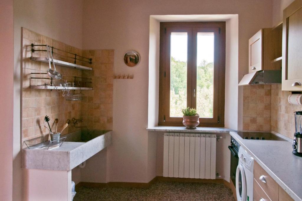 kuchnia ze zlewem i oknem w obiekcie Agriturismo Villa Cheti w mieście Spigno Monferrato