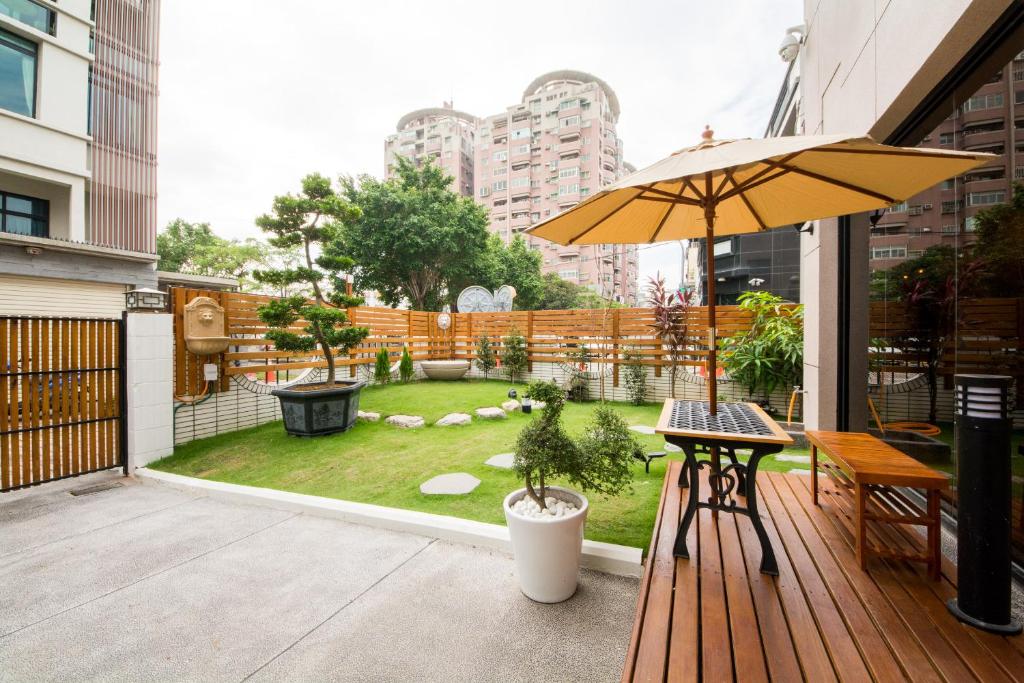 台南的住宿－W2次方，一个带桌子和遮阳伞的庭院