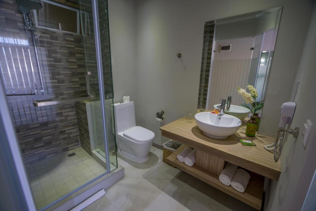 a bathroom with a sink and a toilet and a shower at Le Peninsula Bay Beach Resort & Spa in Blue Bay