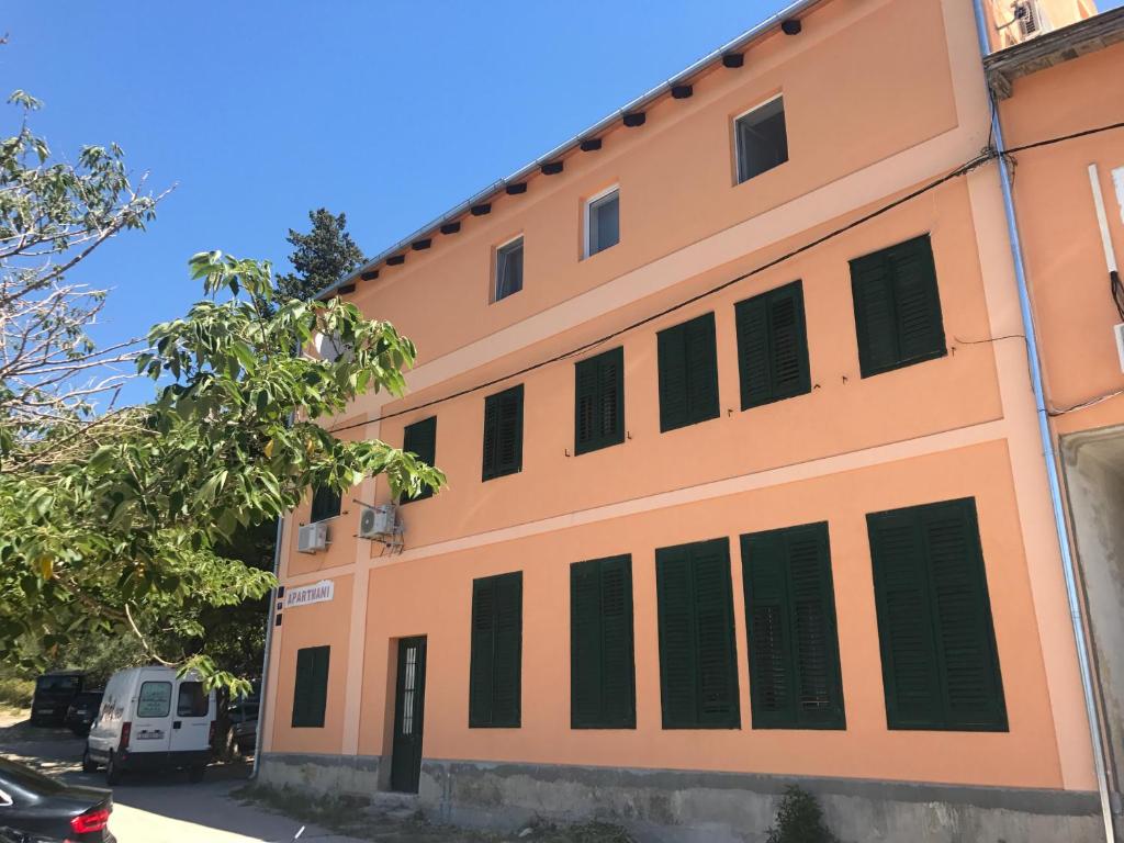 an orange building with black shutters on it at Apartment Bilo in Omiš