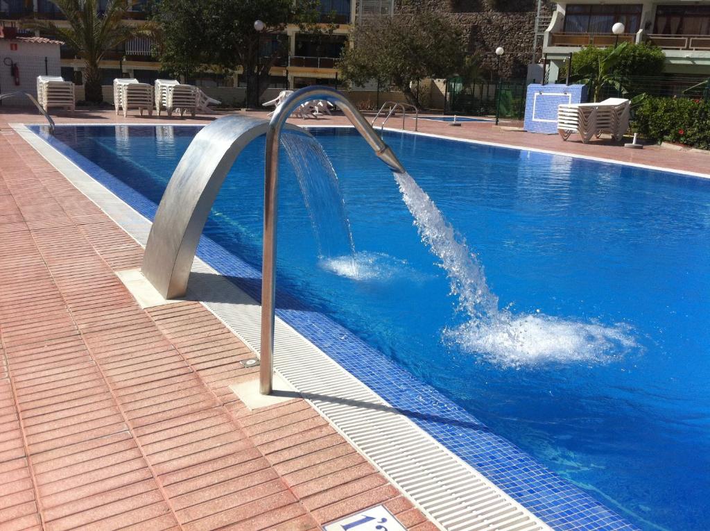 a swimming pool with a water fountain in a building at Apartamentos Australia in Playa del Ingles
