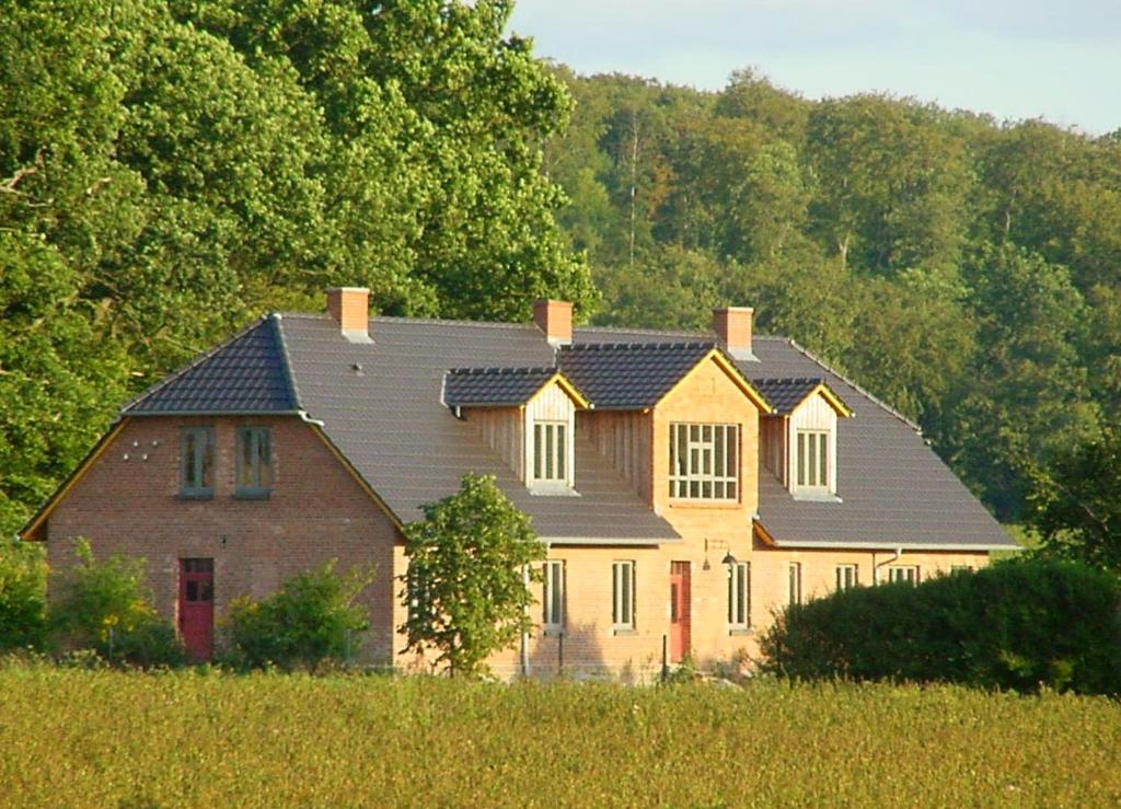 ein großes Haus inmitten eines Feldes in der Unterkunft Forsthof Niendorf in Teterow