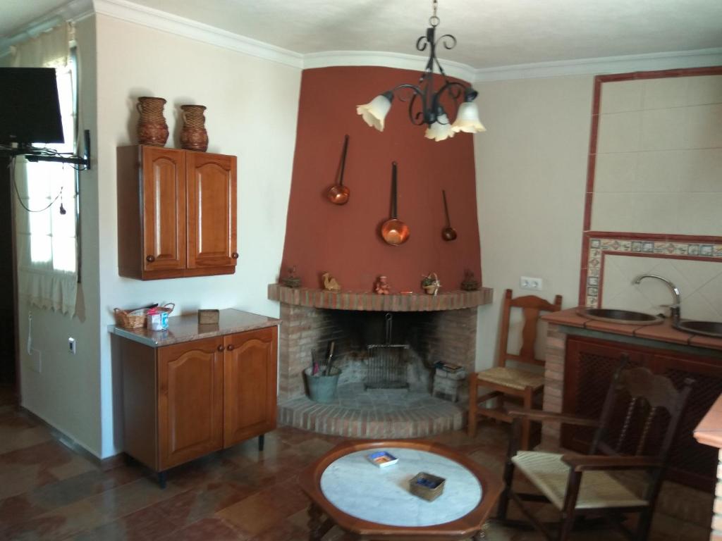 salon z kominkiem i stołem w obiekcie Chacón w mieście Prado del Rey