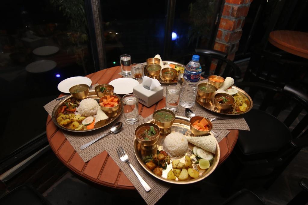 a table with several plates of food on it at Rock Garden Resort in Pokhara
